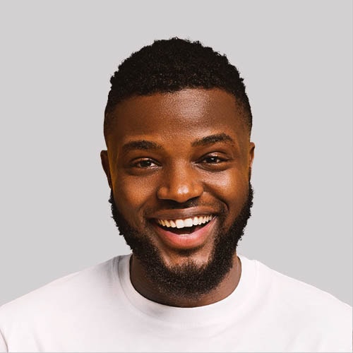 Smiling African American man with a beard and short curly hair.