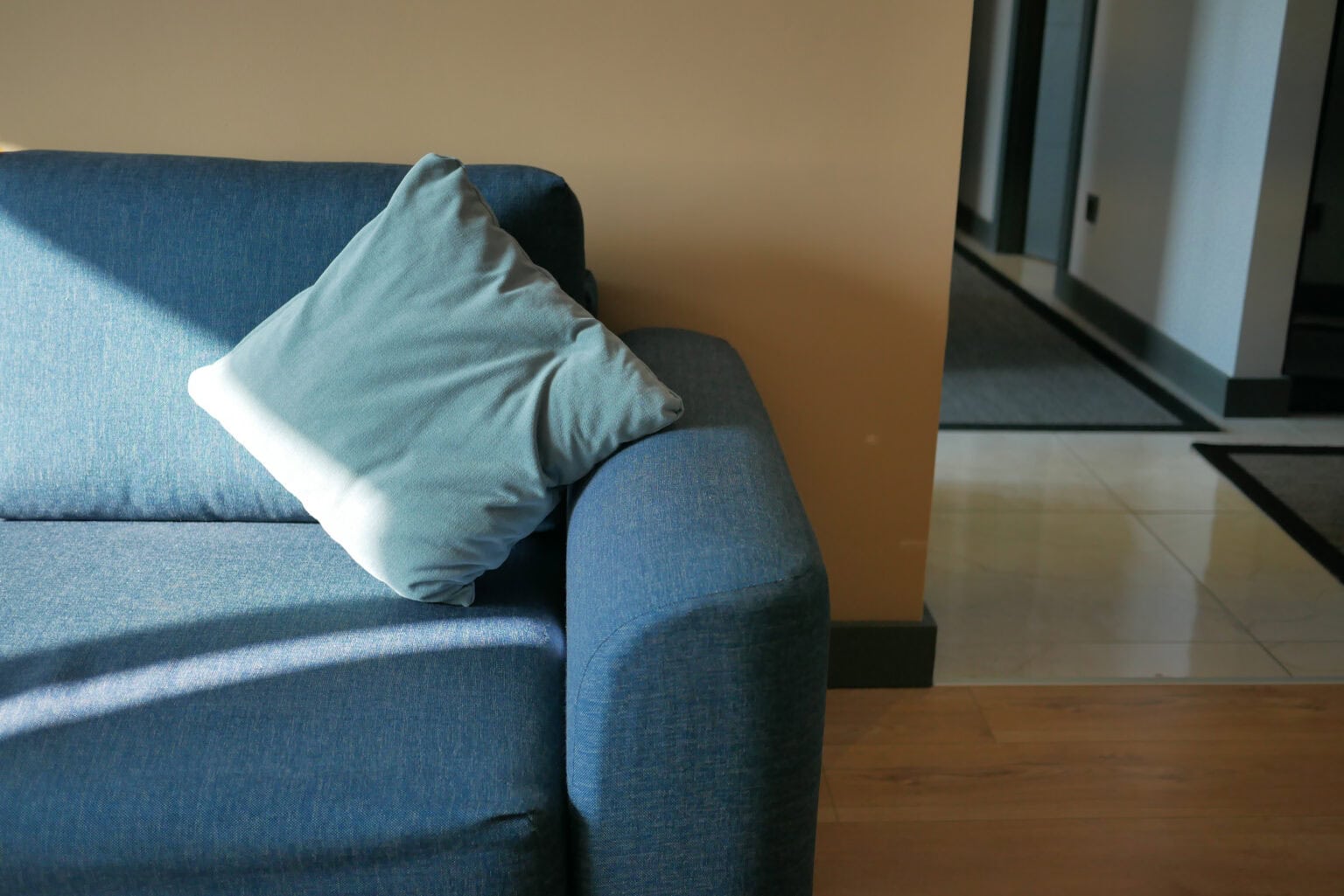 Comfortable blue sofa with a pillow in a modern therapy office setting.